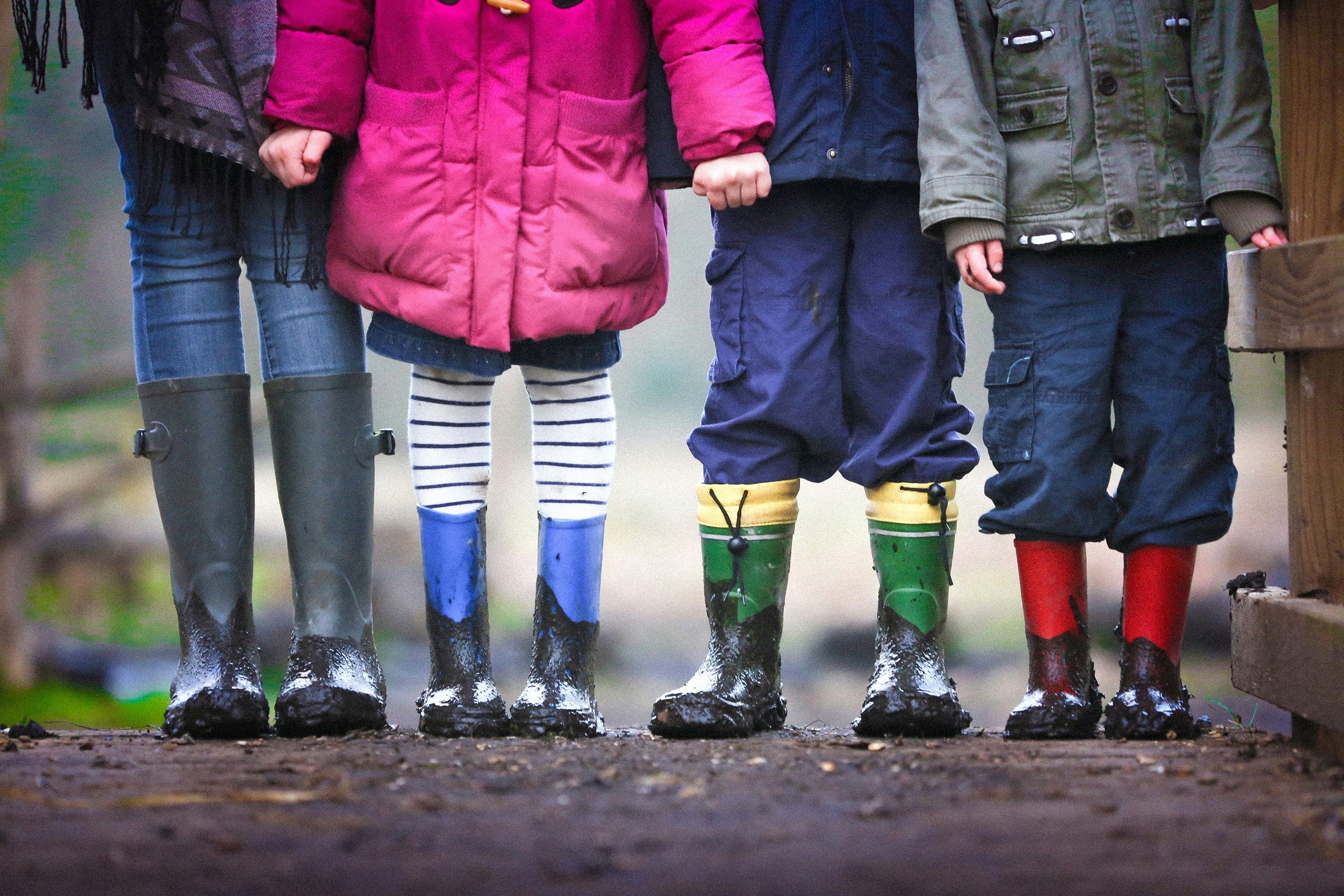 four children standing in mud